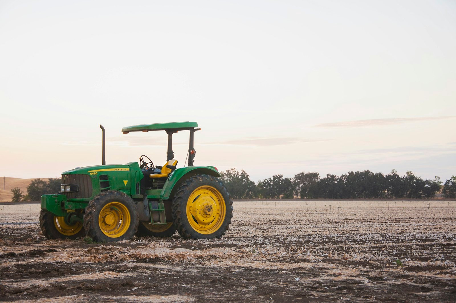 Tractor on open farmland at dusk