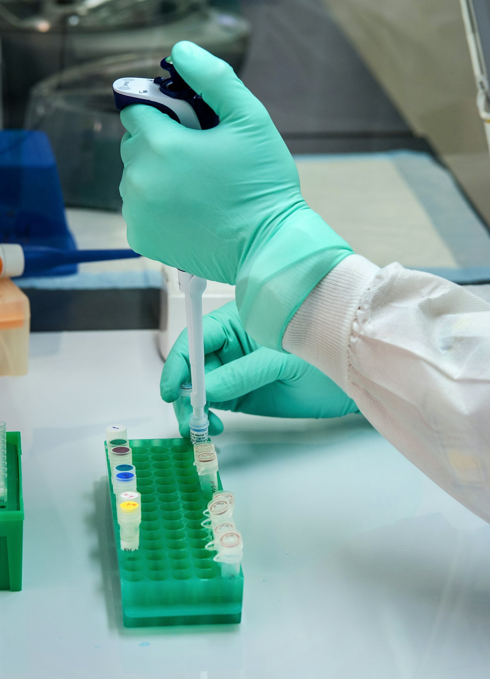 Gloved hand using a pipette in a laboratory