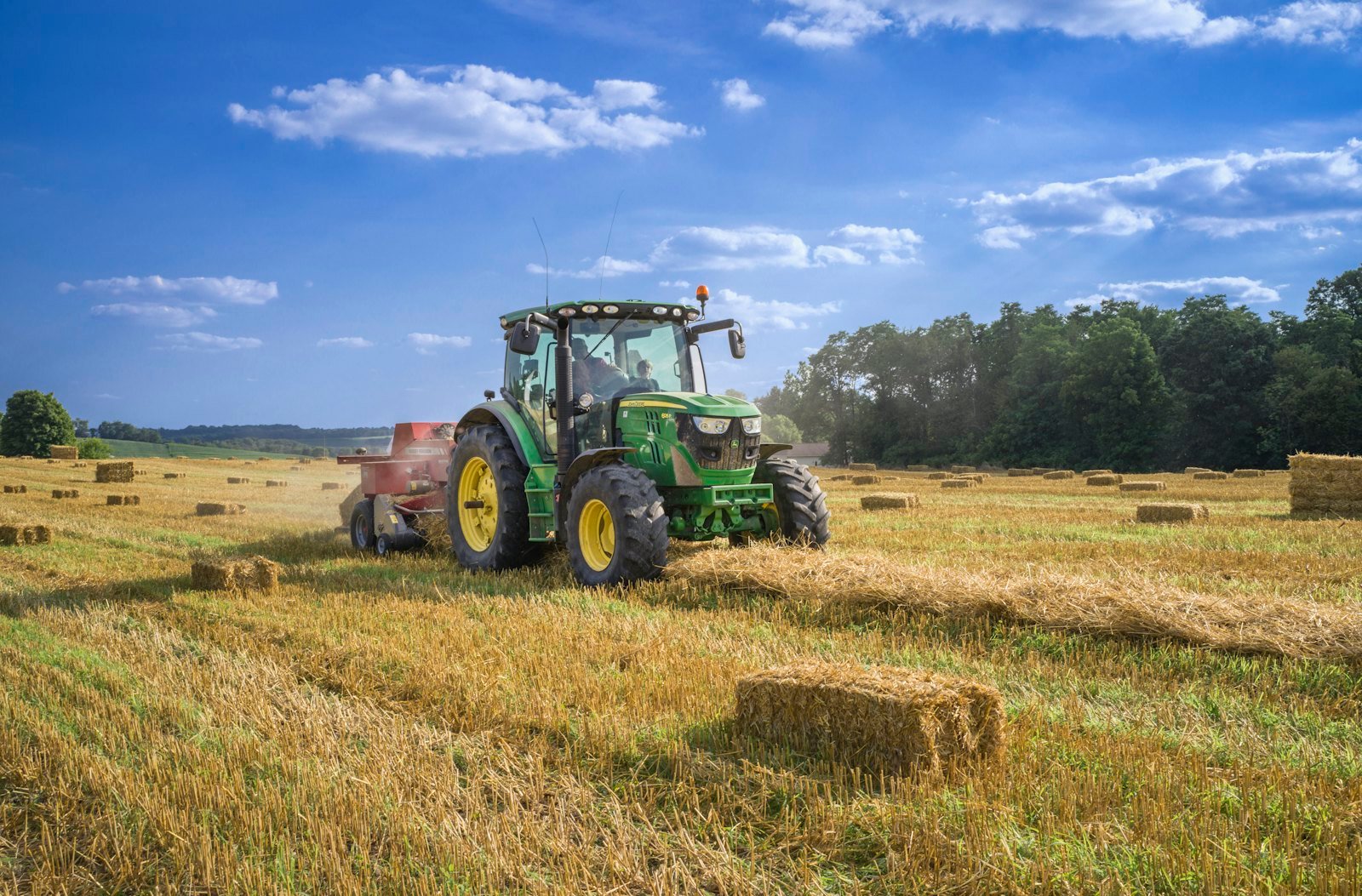 Green tractor in a field under a blue sky